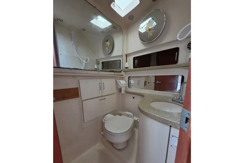 Slide: The Image of 2005 Luhrs 32 Open yacht bathroom with sink, toilet, and mirrors. - 27