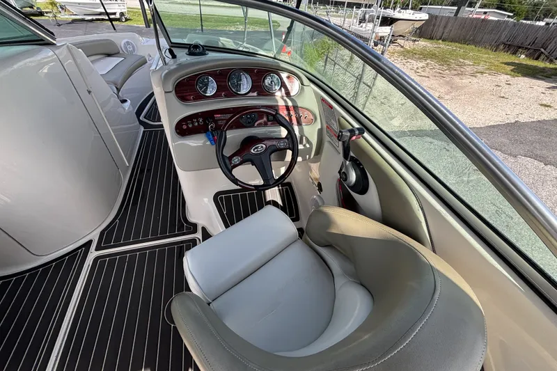 Slide: The Image of 2006 Sea Ray 240 Sundeck boat interior with steering wheel and dashboard controls. - 38