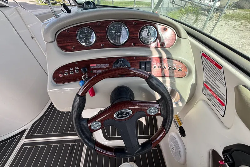 Slide: The Image of Steering console of a 2006 Sea Ray 240 Sundeck boat with wood accents and gauges. - 40