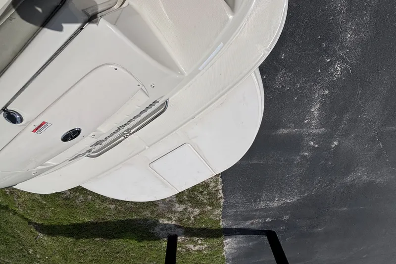 Slide: The Image of 2006 Sea Ray 240 Sundeck boat on pavement, showing rear deck and ladder. - 52
