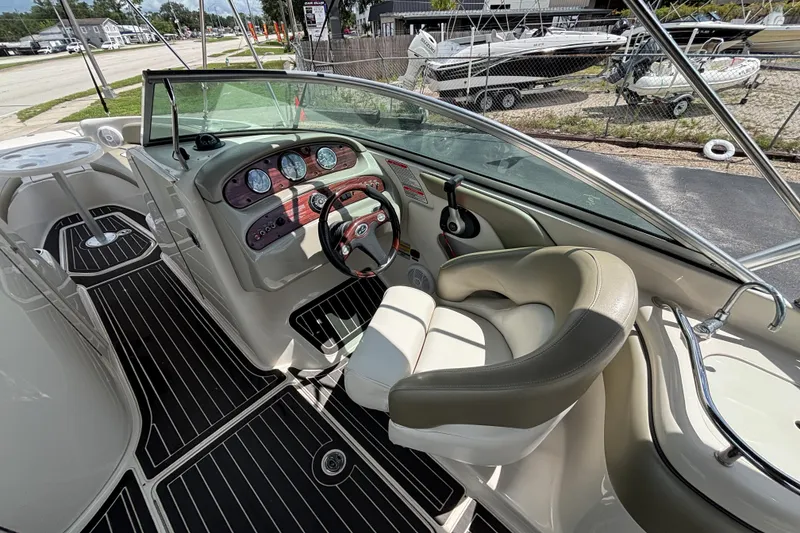 Slide: The Image of 2006 Sea Ray 240 Sundeck boat interior with steering wheel and dashboard controls. - 58