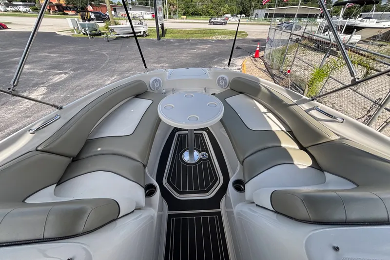 Slide: The Image of 2006 Sea Ray 240 Sundeck boat interior with cushioned seating and round table. - 43