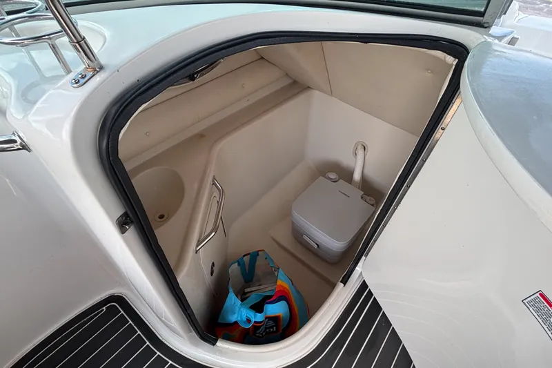 Slide: The Image of Interior of 2006 Sea Ray 240 Sundeck boat with compact toilet and storage area. - 33