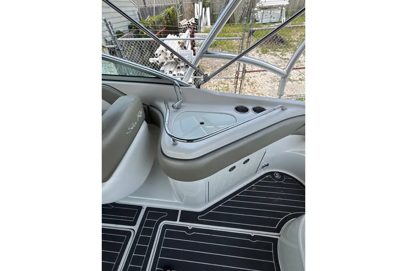 Slide: The Image of 2006 Sea Ray 240 Sundeck interior with seating and cup holders. - 24