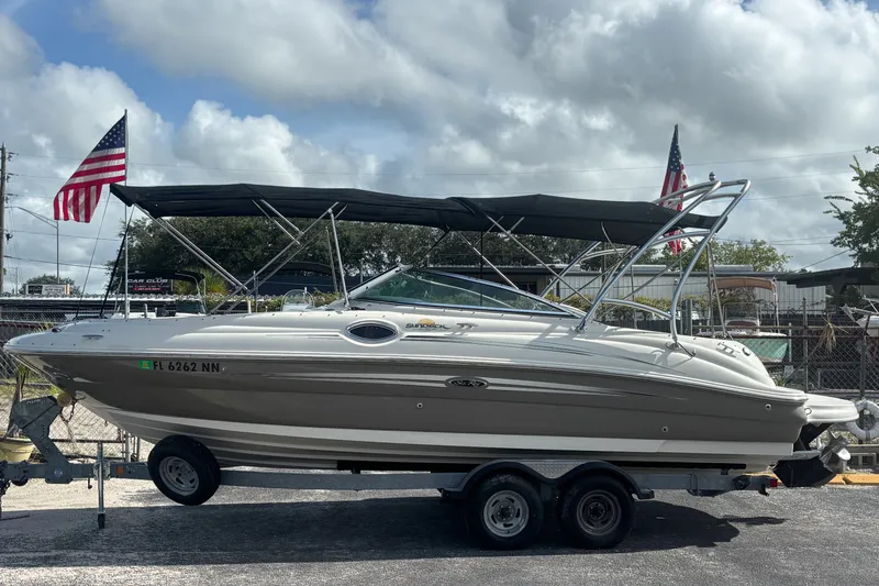 Slide: The Image of 2006 Sea Ray 240 Sundeck boat on trailer, with American flags in the background. - 13