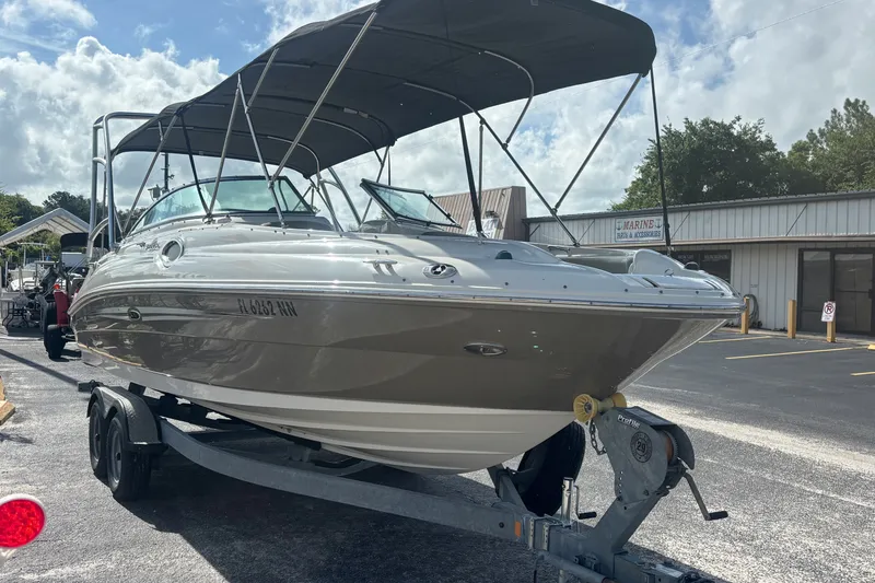Slide: The Image of 2006 Sea Ray 240 Sundeck boat on trailer, parked outdoors under a cloudy sky. - 8