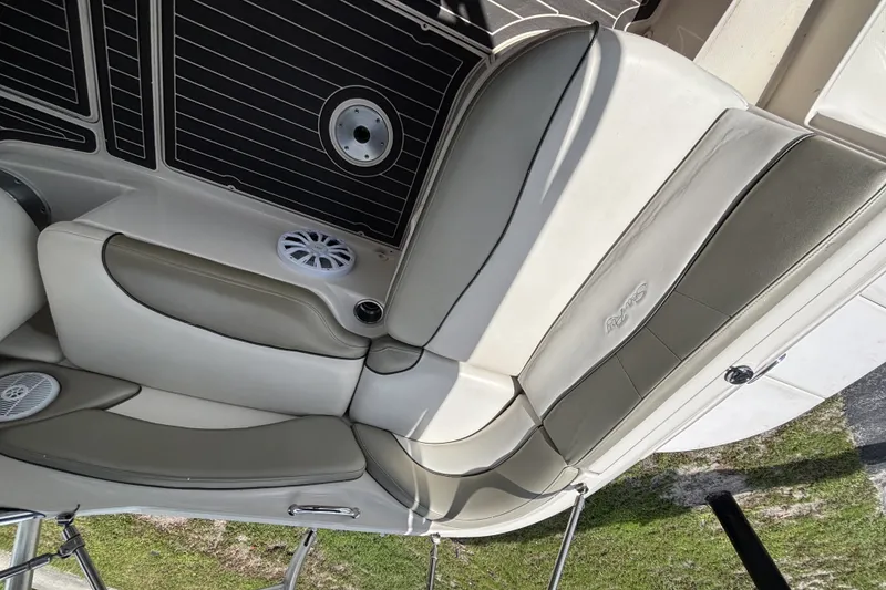 Slide: The Image of 2006 Sea Ray 240 Sundeck interior seating with speaker and cup holder. - 53