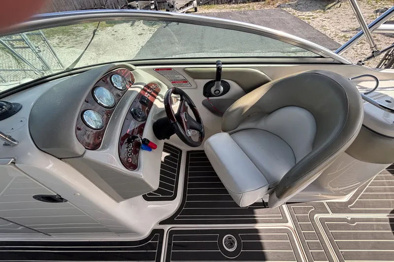 Slide: The Image of 2006 Sea Ray 240 Sundeck cockpit with steering wheel and gauges. - 37