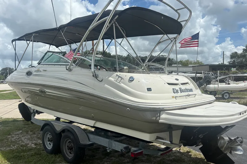 Slide: The Image of 2006 Sea Ray 240 Sundeck boat on trailer with American flags in background. - 11