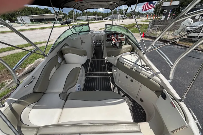 Slide: The Image of 2006 Sea Ray 240 Sundeck interior with seating, steering wheel, and canopy. - 50