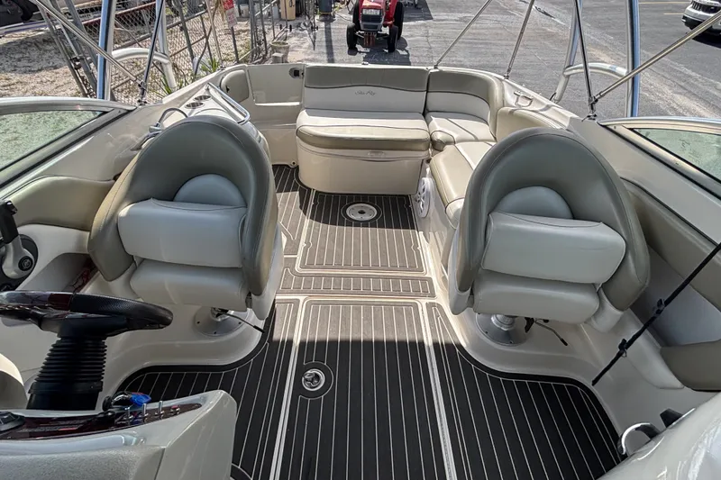 Slide: The Image of 2006 Sea Ray 240 Sundeck interior with seating and steering wheel, showcasing spacious layout. - 18