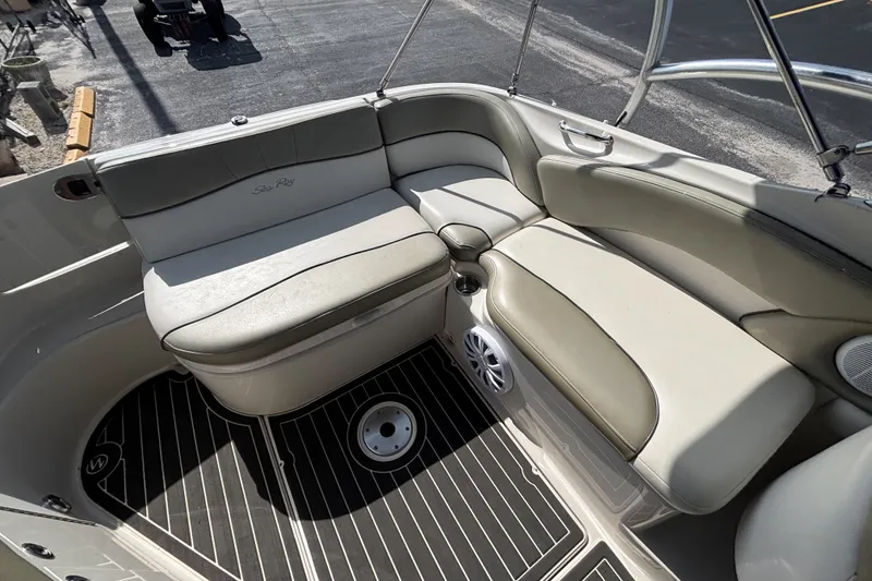 Slide: The Image of Interior seating of a 2006 Sea Ray 240 Sundeck boat, featuring cushioned seats and cup holders. - 41