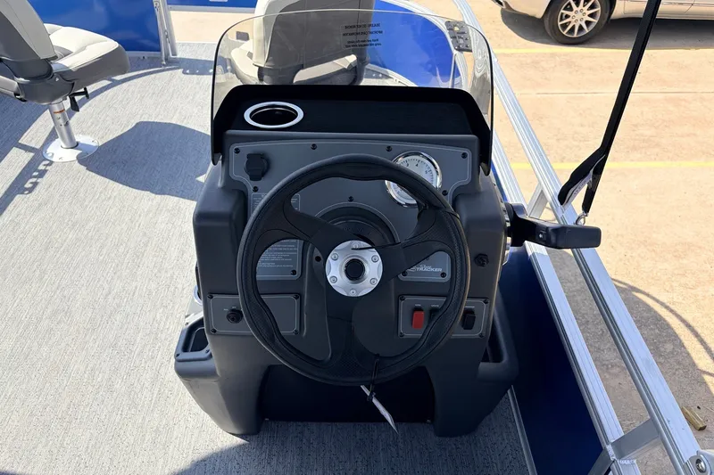 Slide: The Image of 2027 Sun Tracker Party Barge 16 DLX steering console with modern controls and seating. - 18