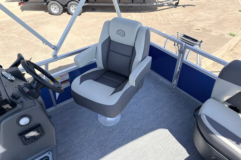 Slide: The Image of 2027 Sun Tracker Party Barge 16 DLX interior with captain's chair and steering console. - 17
