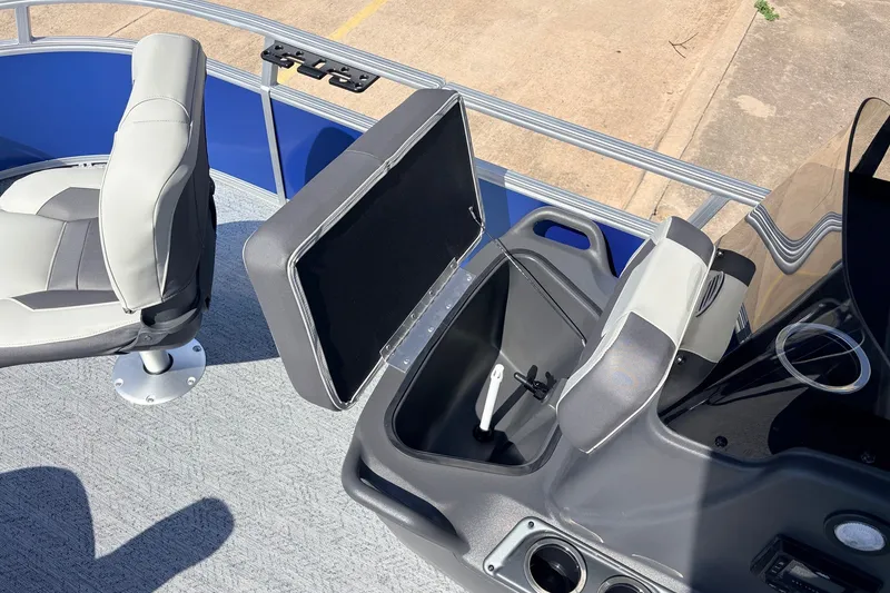 Slide: The Image of 2027 Sun Tracker Party Barge 16 DLX interior with seating and storage compartment. - 16