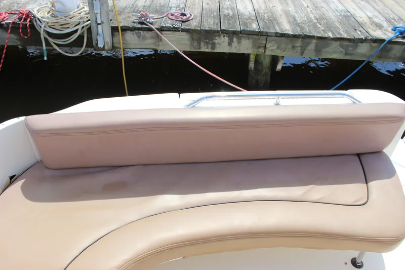 Slide: The Image of Rear seating area of a 2000 Sea Ray Sundancer 310 boat docked by a wooden pier. - 10