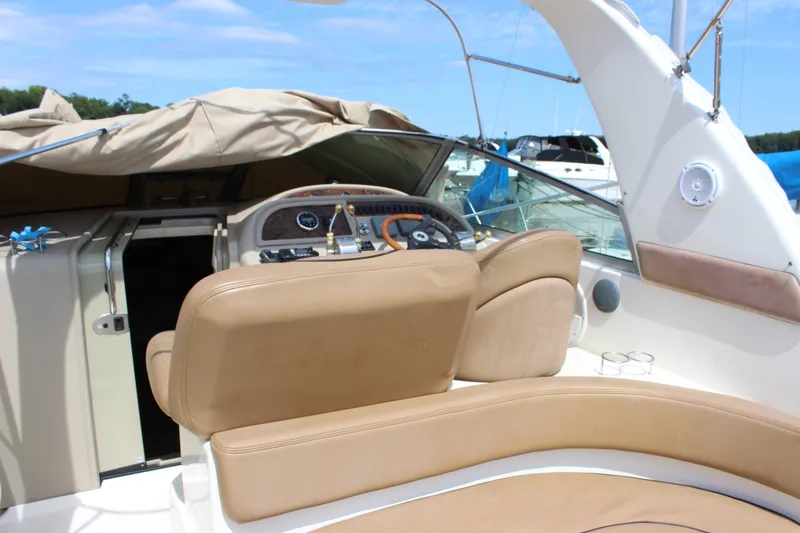 Slide: The Image of The image shows the cockpit of a 2000 Sea Ray Sundancer 310 with beige seats and a helm station. - 23