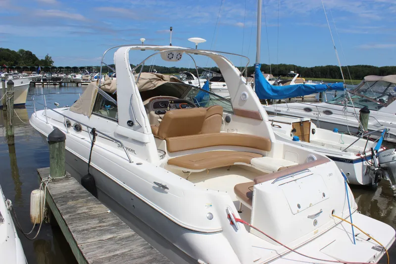 The Image of Sea Ray Sundancer 310, 2000 model, docked at a marina under a clear blue sky. - 11
