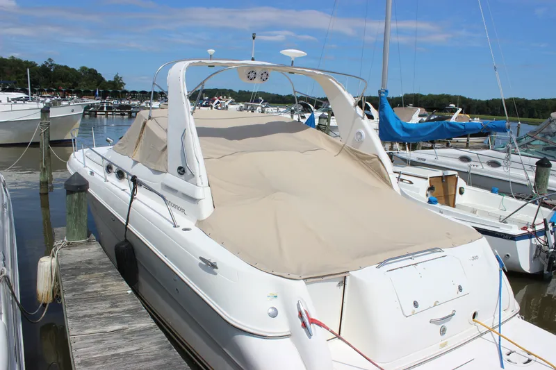 Slide: The Image of 2000 Sea Ray Sundancer 310 docked at marina, covered with beige tarp. - 30