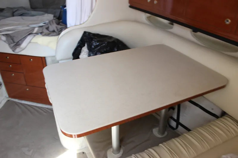 Slide: The Image of Interior of a 2000 Sea Ray Sundancer 310, featuring a compact dining area. - 25