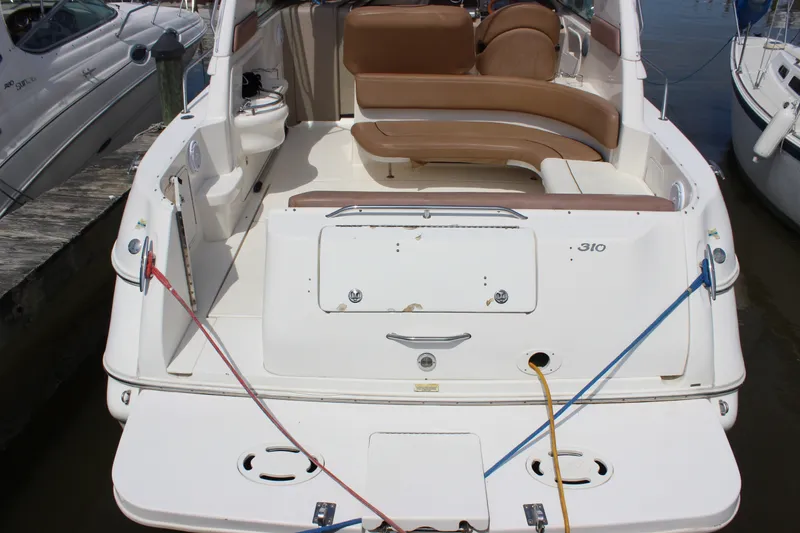 Slide: The Image of 2000 Sea Ray Sundancer 310 boat docked, featuring spacious seating and clean deck design. - 12