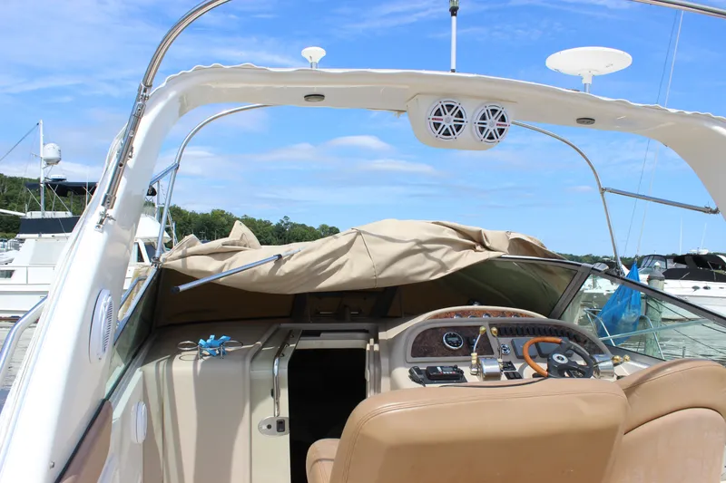Slide: The Image of 2000 Sea Ray Sundancer 310 boat interior with helm, docked under clear blue sky. - 4