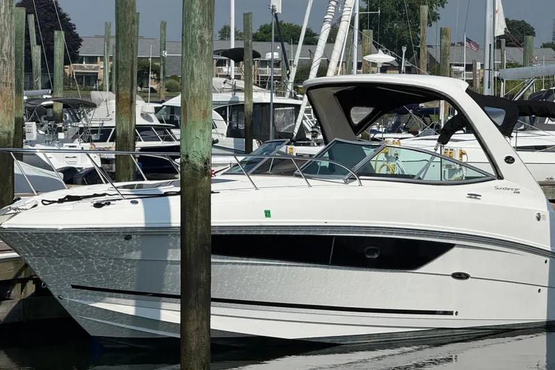 Slide: The Image of 2012 Sea Ray Sundancer 310 docked at a marina, surrounded by other boats. - 0