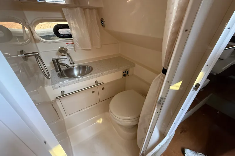 Slide: The Image of 2012 Sea Ray Sundancer 310 bathroom with sink, toilet, and window. - 30