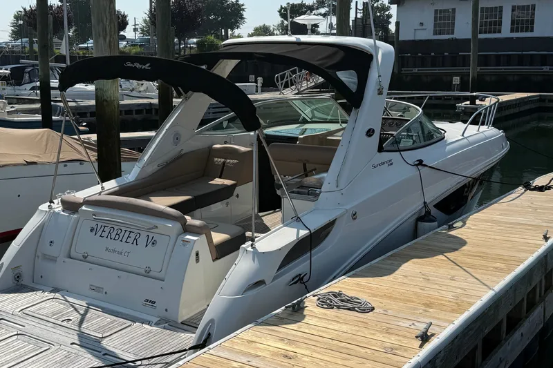 Slide: The Image of 2012 Sea Ray Sundancer 310 docked, featuring sleek design and spacious seating area. - 2