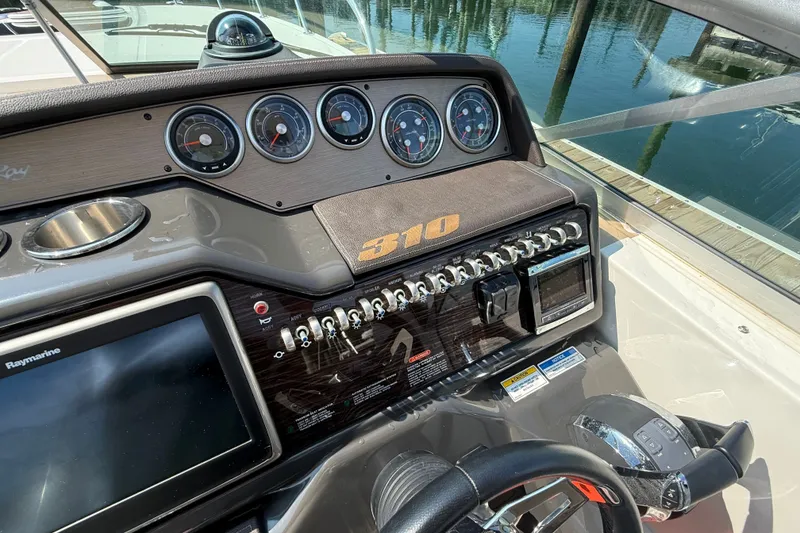Slide: The Image of Control panel of a 2012 Sea Ray Sundancer 310 boat, featuring gauges and navigation equipment. - 11