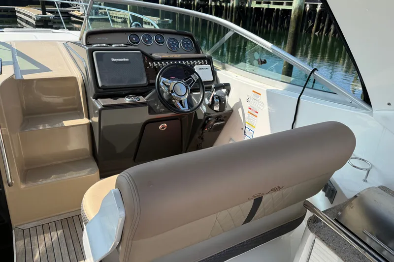 Slide: The Image of 2012 Sea Ray Sundancer 310 helm with modern controls and comfortable seating. - 9