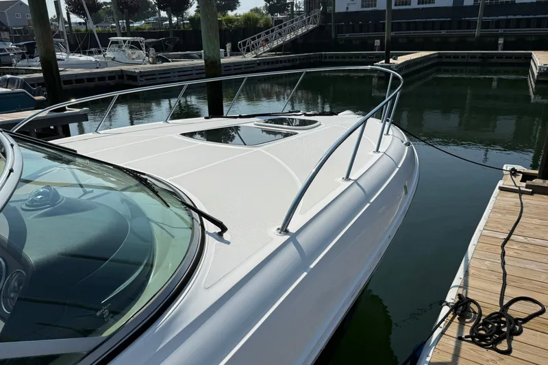 Slide: The Image of 2012 Sea Ray Sundancer 310 docked at marina, showcasing sleek design and polished deck. - 5