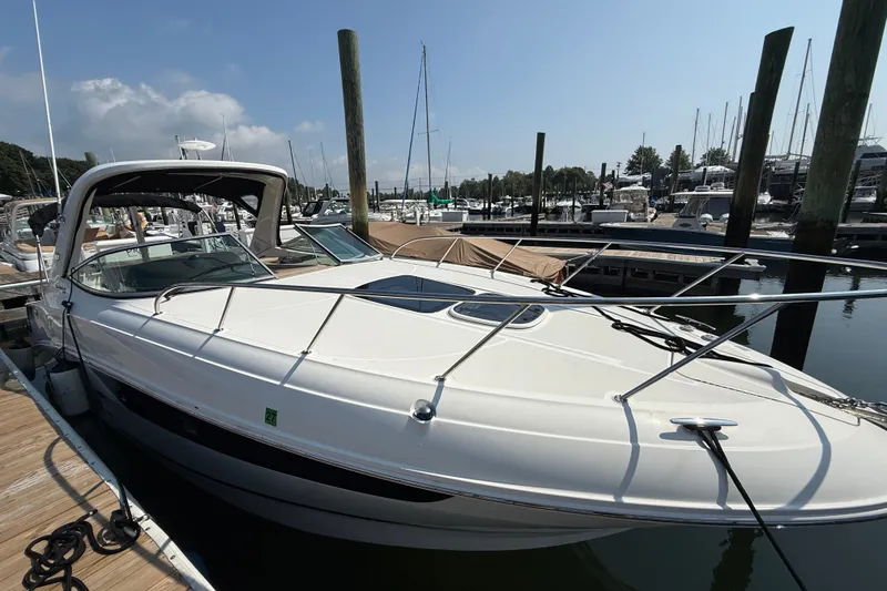 Slide: The Image of 2012 Sea Ray Sundancer 310 docked at a marina under a clear blue sky. - 6