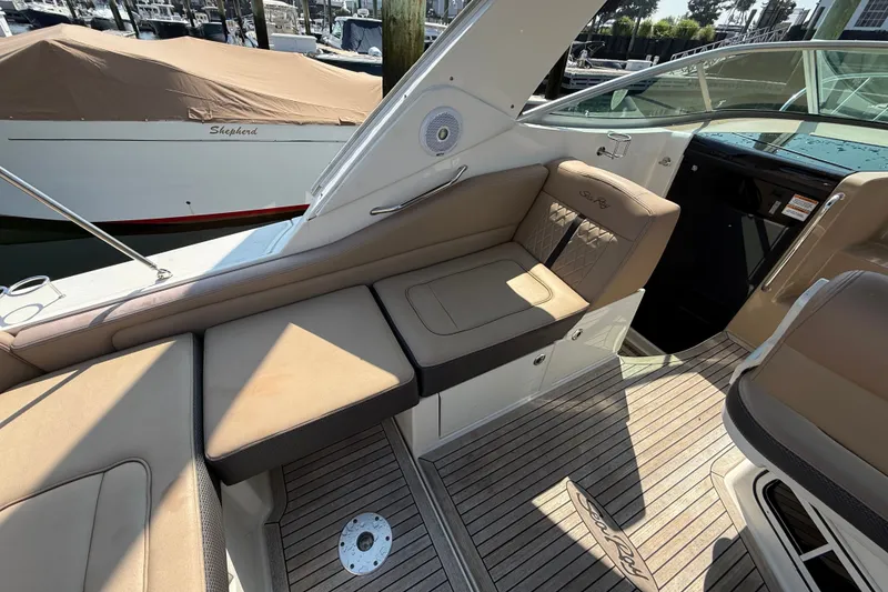 Slide: The Image of Interior of a 2012 Sea Ray Sundancer 310 boat with beige seating and wood flooring. - 16