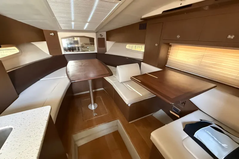 Slide: The Image of Interior of 2012 Sea Ray Sundancer 310 yacht with elegant seating and wooden table. - 18