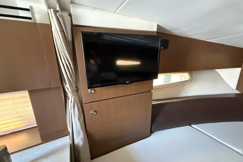 Slide: The Image of Interior of 2012 Sea Ray Sundancer 310 with mounted TV and modern wood paneling. - 22