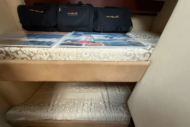 Slide: The Image of Interior of 2005 Sea Ray 500 Sedan Bridge with patterned bedding and Sea Ray bags. - 25