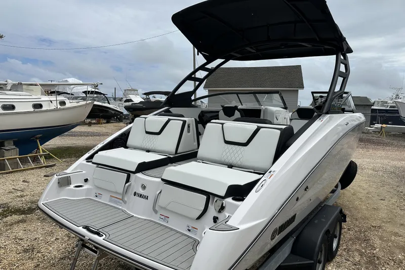 Slide: The Image of 2025 Yamaha Boats 252SD with sleek design and comfortable seating, docked outdoors. - 5