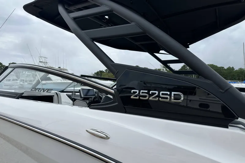 Slide: The Image of 2025 Yamaha Boats 252SD, sleek design with modern features, docked at marina. - 18