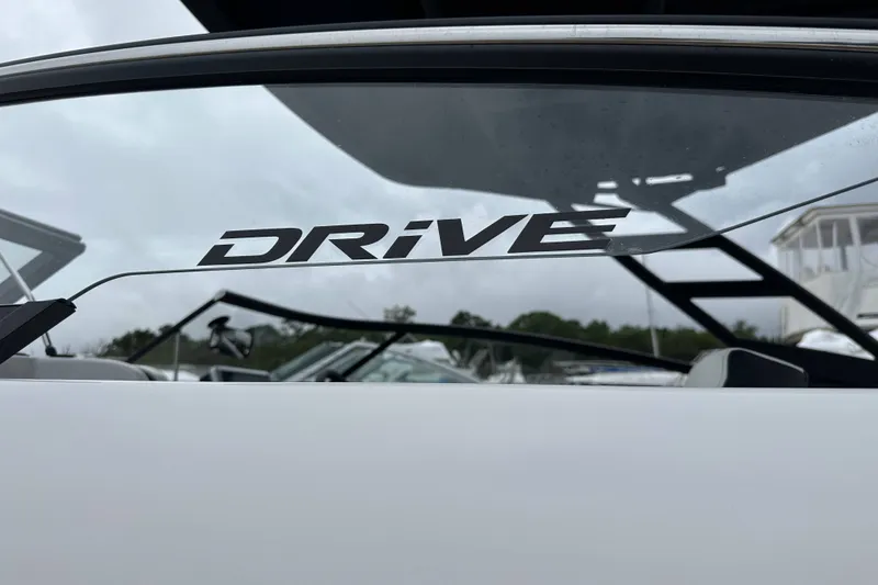 Slide: The Image of 2025 Yamaha Boats 252SD windshield with "Drive" decal, showcasing sleek design. - 19