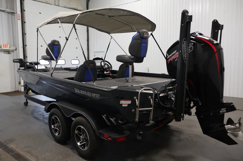 Slide: The Image of 2023 Ranger RT188P boat with canopy and Mercury Pro XS engine in a garage setting. - 7