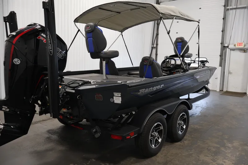 Slide: The Image of 2023 Ranger RT188P fishing boat with canopy and dual seats in a garage setting. - 5