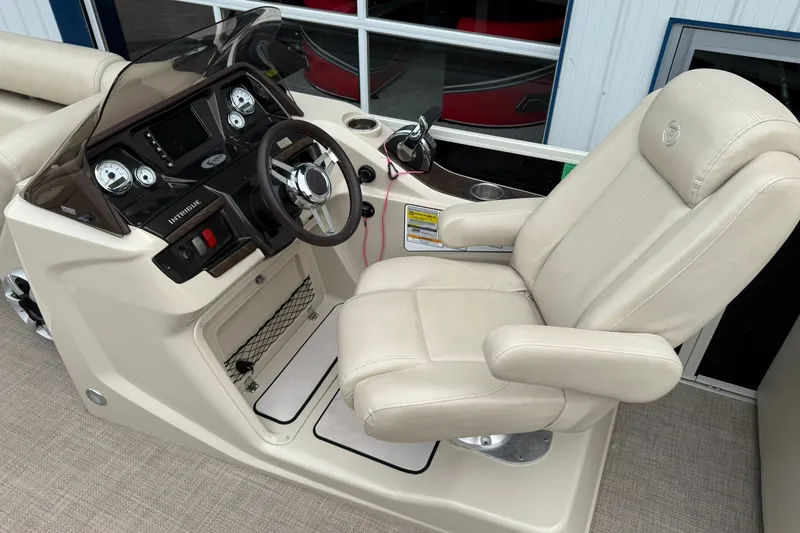 Slide: The Image of Captain's chair and helm of 2016 Premier 270 Intrigue RF boat, featuring modern controls. - 16