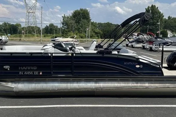 Slide: The Image of 2020 Harris Solstice 230 SL pontoon boat parked in a marina with other boats. - 11