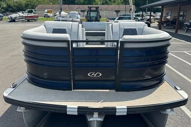 Slide: The Image of 2020 Harris Solstice 230 SL pontoon boat with sleek design in a marina setting. - 2
