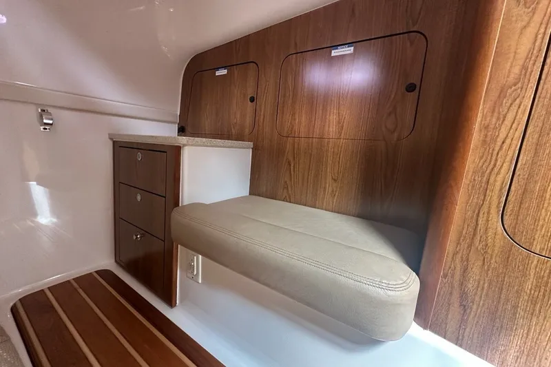 Slide: The Image of 2013 Pursuit OS 345 Offshore cabin interior with wood paneling and cushioned seating. - 17