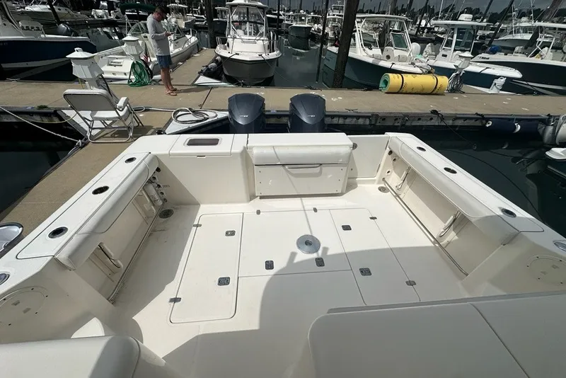 Slide: The Image of 2013 Pursuit OS 345 Offshore boat docked at marina, spacious deck view. - 25