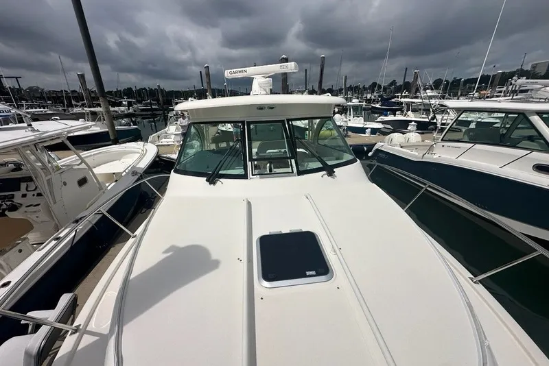 Slide: The Image of 2013 Pursuit OS 345 Offshore boat docked at a marina under cloudy skies. - 33