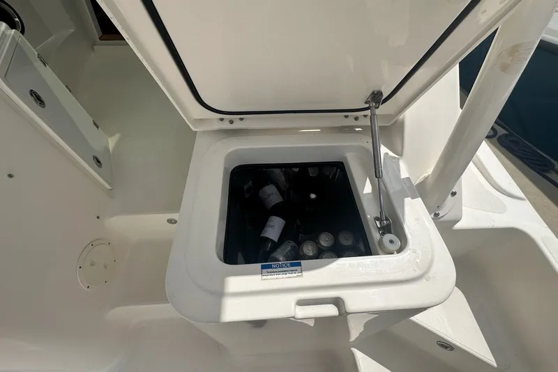 Slide: The Image of Open storage compartment on 2013 Pursuit OS 345 Offshore boat, containing beverages. - 30