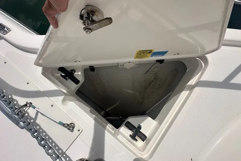 Slide: The Image of Open anchor locker on a 2013 Pursuit OS 345 Offshore boat, showing storage compartment. - 36